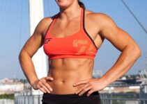 Stacie Tovar smiling while standing on top of a building, looking fit and ripped